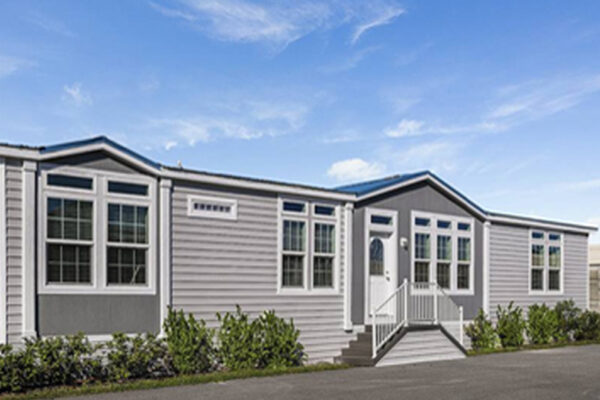 Photo of a double wide manufactured home with grey lap siding with accented dark grey under the two dormers